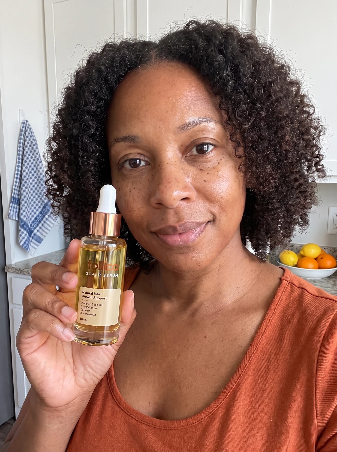 Black woman holding Follica scalp serum