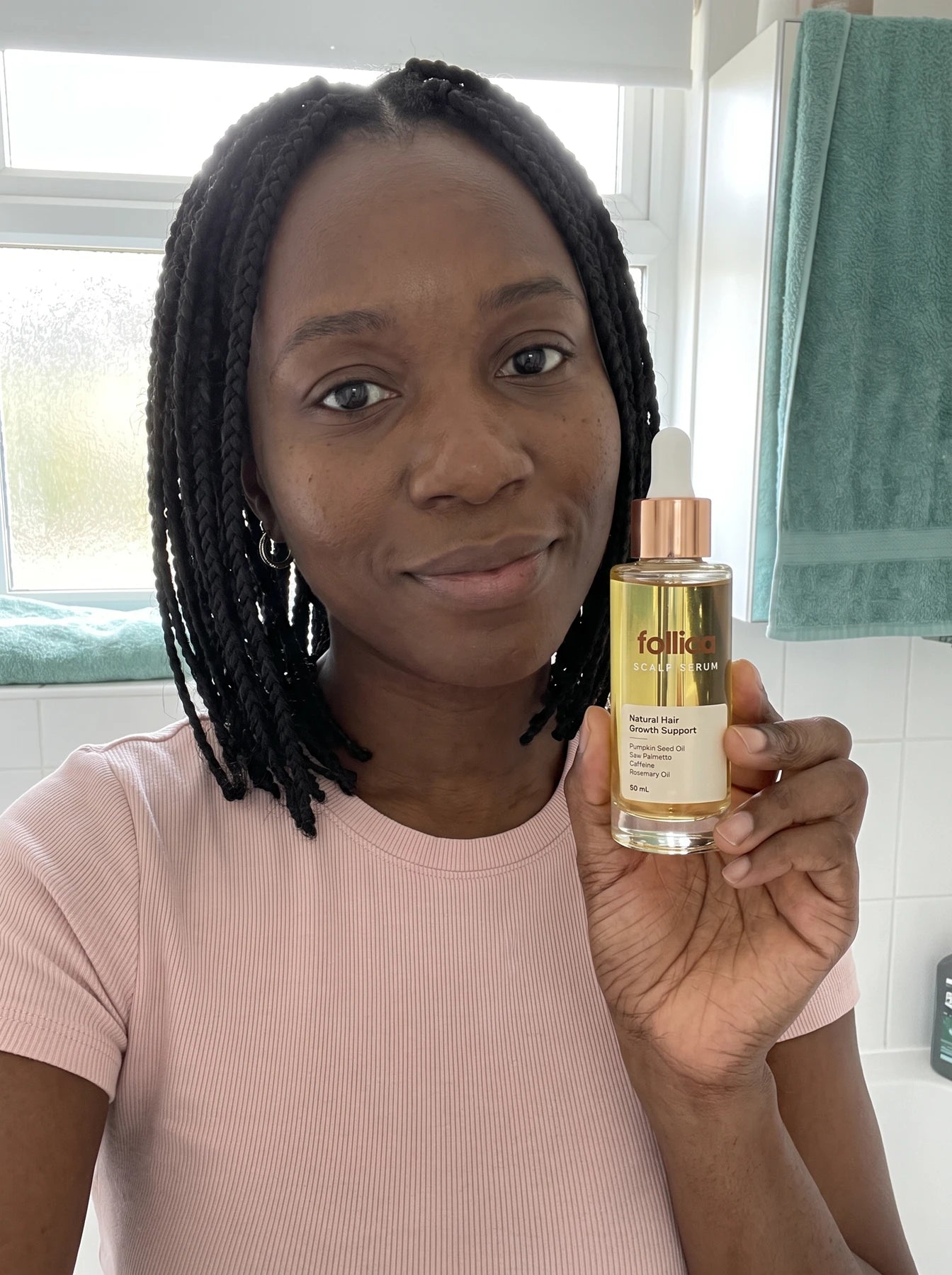 Black woman holding Follica scalp serum